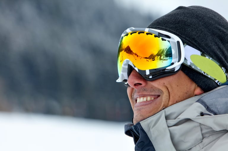skier smiling and wearing ski glasses in the mountains